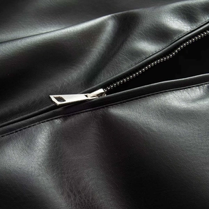 Detailed macro view of the premium matte black faux leather texture and silver metal zipper
