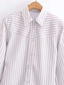 Detailed view of grey and white striped shirt with contrasting yoke and white buttons
