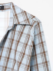 Detail view of classic light blue and brown plaid shirt collar with high texture fabric