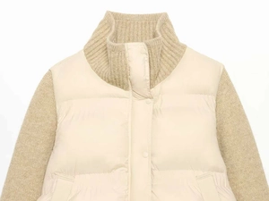 Close-up of cream knit puffer jacket featuring mixed material and quilted texture details