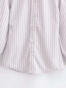 Detailed view of light purple and white vertical stripes with white resin buttons on shirt