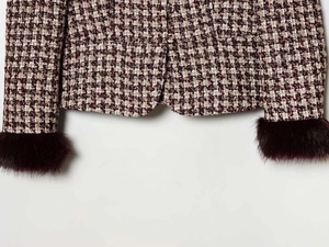 Detail of houndstooth tweed blazer featuring luxury faux fur cuffs and button closure
