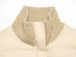 Detail of high neck winter jacket with ribbed knit lining and secure button closure