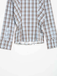 Detail of light blue plaid shirt featuring brown check patterns and buttoned cuffs