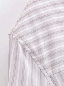 Close-up of shoulder seam stitching on light grey and white vertical striped shirt