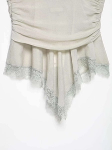 Detail of light gray camisole featuring ruching texture and delicate lace trim at hem