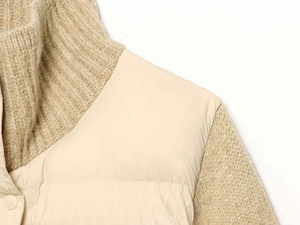 Close-up of cable knit stitching and quilted fabric on winter puffer jacket