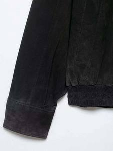 Detailansicht der schwarzen Wildlederjacke mit elastischen Rippbündchen und Saumnähten