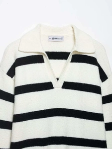 Close-up of the elegant black and white striped V-neck collar and knit texture