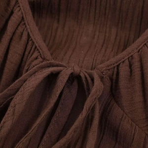 Macro detail of deep brown pleated midi dress featuring fine neckline drawstring ties