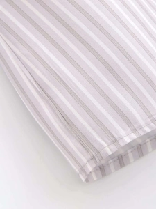 Close-up of fine stitching and light gray striped cotton fabric texture on shirt cuff