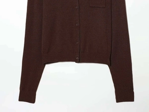 Detail of dark brown knit cardigan with buttons, square pocket and ribbed hem texture
