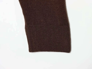 Detailed macro view of the dark brown knitted cuff with high-density ribbed texture