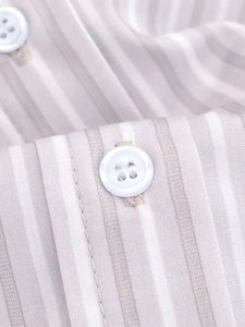 Macro shot of vertical striped fabric with white four-hole button and stitching detail