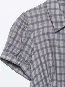 Detail of grey gingham summer dress featuring classic collar and pleated puff sleeve design