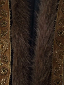 Detailed embroidery with golden sequins and plush faux fur trim on a brown velvet vest
