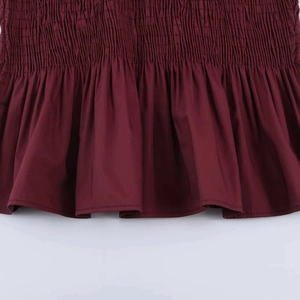 Detail of smocked waist and ruffle trim on this dark red sleeveless summer shirt
