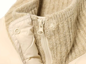Detail of knit rib collar and quilted fabric with gold zipper on winter jacket