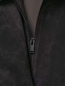 Detailaufnahme des matten schwarzen Reißverschlusses und braunen Futters der Lederjacke