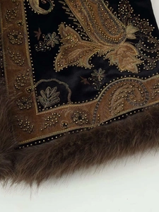 Detail of vintage black velvet vest with gold paisley embroidery and faux fur trim edges
