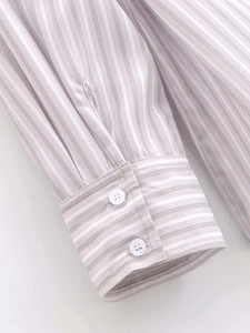 Close-up of double-button cuffs with contrasting horizontal stripes on striped shirt