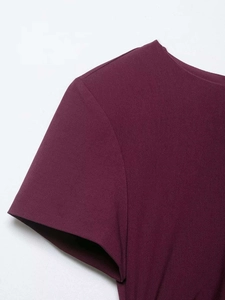 Détail de l'encolure ronde et des coutures sur une robe bordeaux à manches courtes