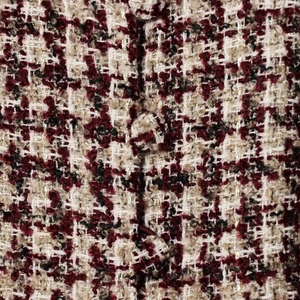 Elegant tweed blazer detail with gold metallic threads and matching fabric-covered button
