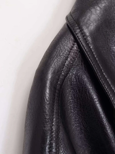 Detail macro of black leather texture with high-quality double stitching on the jacket