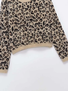 Detailed macro view of soft leopard print fuzzy knit fabric with ribbed cuffs and hem