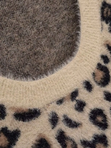 Close-up detail of the ribbed neckline on a leopard print fuzzy knit sweater