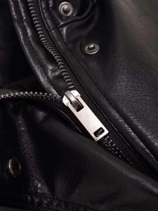 Detailed macro view of black faux leather texture with silver metal zipper and snap button