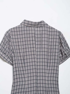 Detail view of grey gingham pattern with vintage shirt collar and puff sleeves on a dress