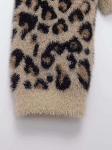 Close-up of leopard print faux fur texture on the cuff of a cozy knit sweater