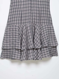 Detail view of the tiered ruffle hem and grey gingham pattern on a summer mini dress