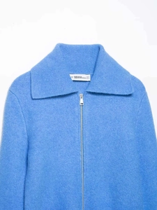 Detail of the light blue knit texture and silver metal zipper on the lapel collar sweater