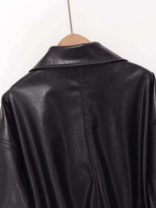 Close-up of black PU leather jacket texture on collar and shoulder with grain finish