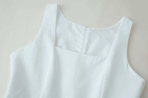 Close-up of white sleeveless dress showing square neckline and back invisible zipper