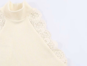 Dettaglio del top in maglia a lupetto con delicato bordo in pizzo beige sulle spalle