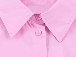Detail view of the pink poplin shirt collar with matching buttons and neat stitching