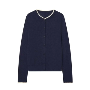 Detailed close-up of navy knit cardigan featuring white scalloped lace trim collar