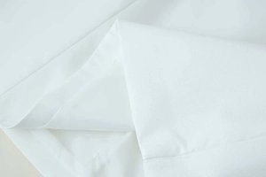 Macro shot of high-quality white breathable fabric with professional stitched hemming details