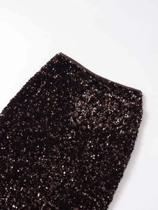 Detail shot of shimmering coffee brown sequins on a stylish mini skirt with waistband