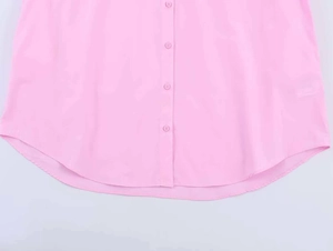 Close-up of light pink poplin shirt with single-breasted buttons and curved hem detail