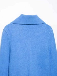 Detailed back view of the neckline and shoulder seams on a light blue knit sweater
