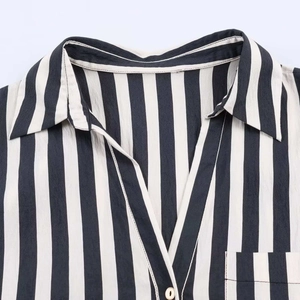 Close-up detail of a striped shirt showing the lapel collar, V-neckline, and cotton texture