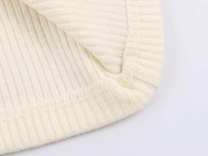 Dettaglio ravvicinato del tessuto in maglia a coste crema con cucitura piatta di qualità