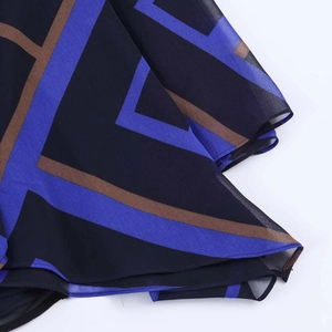 Detail of geometric pattern on lightweight chiffon fabric with blue and brown blocks