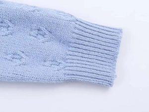Gros plan sur le revers de cardigan en maille bleu clair avec texture côtelée