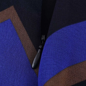 Asymmetric midi skirt featuring geometric color blocks and invisible zipper detail