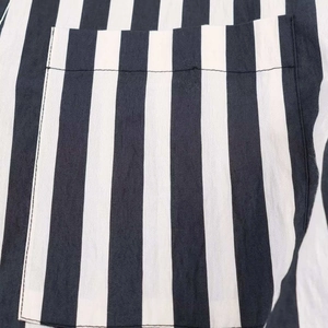 Detailed close-up of a striped shirt pocket with precise stitching and cotton fabric